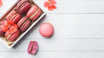 Pink dessert macaron or macaroons in a box on a white background. Copy space.