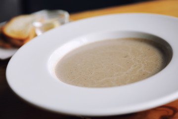 Apptetizer mushroom soup with bread on wood background