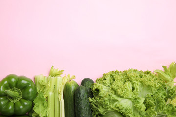 Flat lay composition with fresh salad ingredients on pink background, space for text