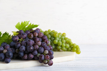 Fresh ripe juicy grapes on white wooden table