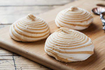 Vanilla marshmallow zephyr with caramel on a wooden table. Selective focus. Copy space.