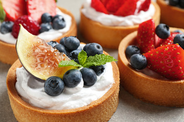 Delicious sweet pastries with berries on grey table, closeup