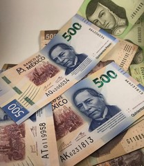 Fototapeta na wymiar Mexican peso bills isolated on white background