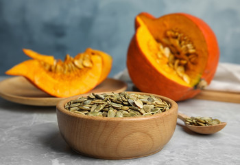 Bowl of raw pumpkin seeds on light grey marble table