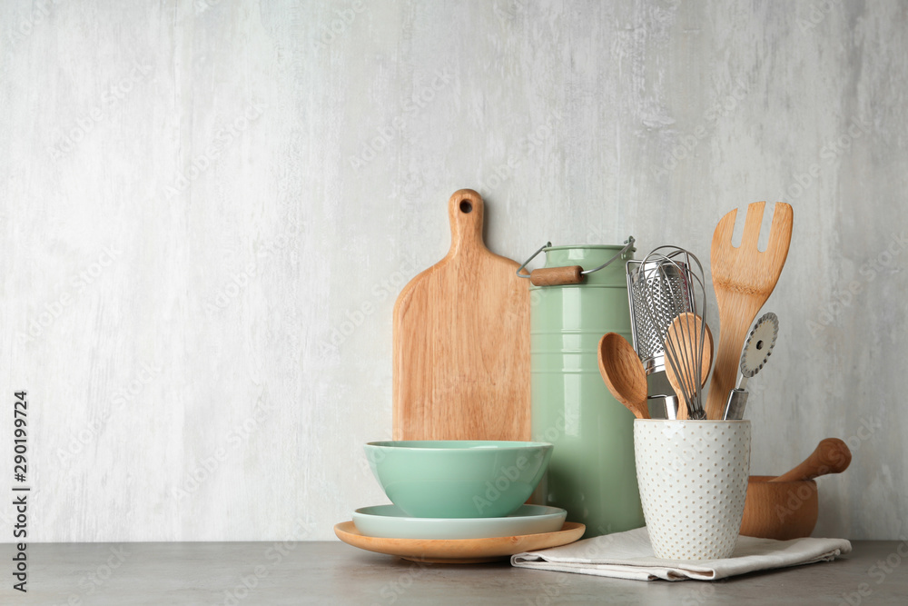 Canvas Prints Different kitchen utensils on grey table against light background. Space for text