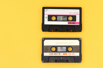 Old audio tape cassettes on a bright yellow background. Top view, old technology concept