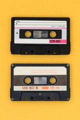 Old audio tape cassettes on a bright yellow background. Top view, old technology concept