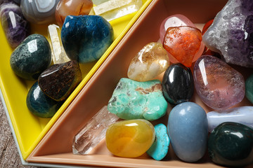 Plastic tray with different beautiful gemstones on table