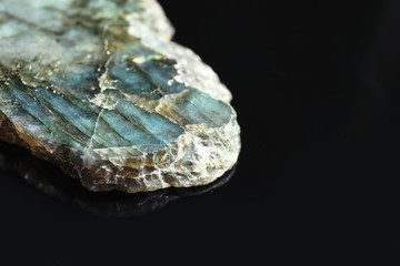 Beautiful labradorite gemstone on black background, closeup. Space for text