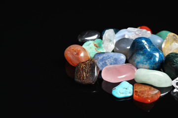 Naklejka premium Different beautiful gemstones on black background. Space for text