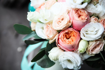  bouquet of white and beige roses lies on a wooden background