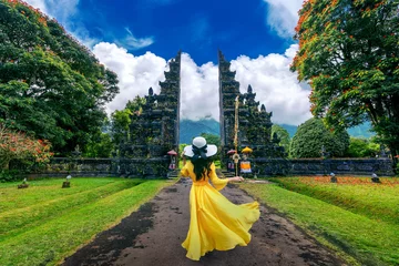 Fototapeten Bali Woman walking at big entrance gate, Bali in Indonesia.  © tawatchai1990