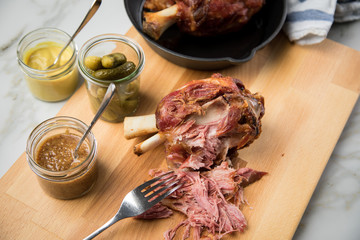 Gegrilltes Schweinefleisch Haxen Fleisch auf Holzbrett mit Cornichons, süßen und mittelscharfen...