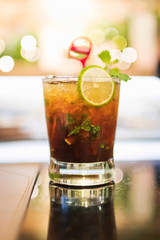 Mojito cocktail with reflection on a table,  glittering light on background. 