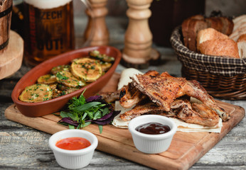 chicken legs with potatoes on a wooden stand