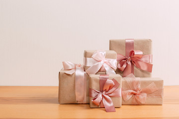 set of beautiful different gift boxes made by handmade with pink bows on a wooden table with a light background. flat lay