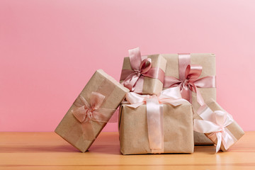 set of beautiful different gift boxes made by handmade with pink bows on a wooden table with a pink background. flat lay