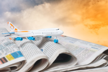 The plane on the newspaper media against the sky, the concept of news.