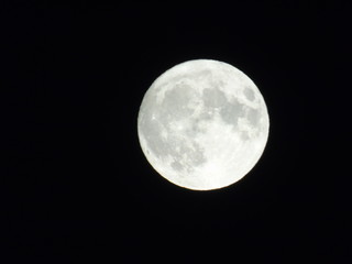 An amazing photography of the full moon over the city of Genova by night with a great clear sky in background and some stars