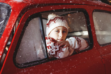 Boy ride in red Christmas car.