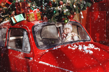 Boy ride in red Christmas car.