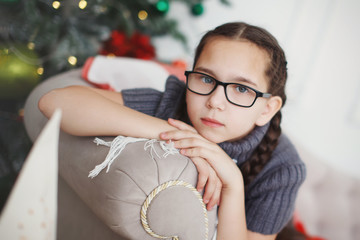 Teen girl in glasses with pigtails.