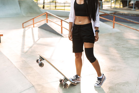 Cropped image of a girl teenager standing with longboard