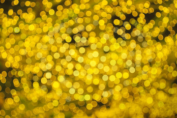 Abstract beautiful blurred gold yellow colored bokeh from ornamental lights flickering in the park....