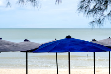 Closeup image of beach umbrellas with sea and sky background
