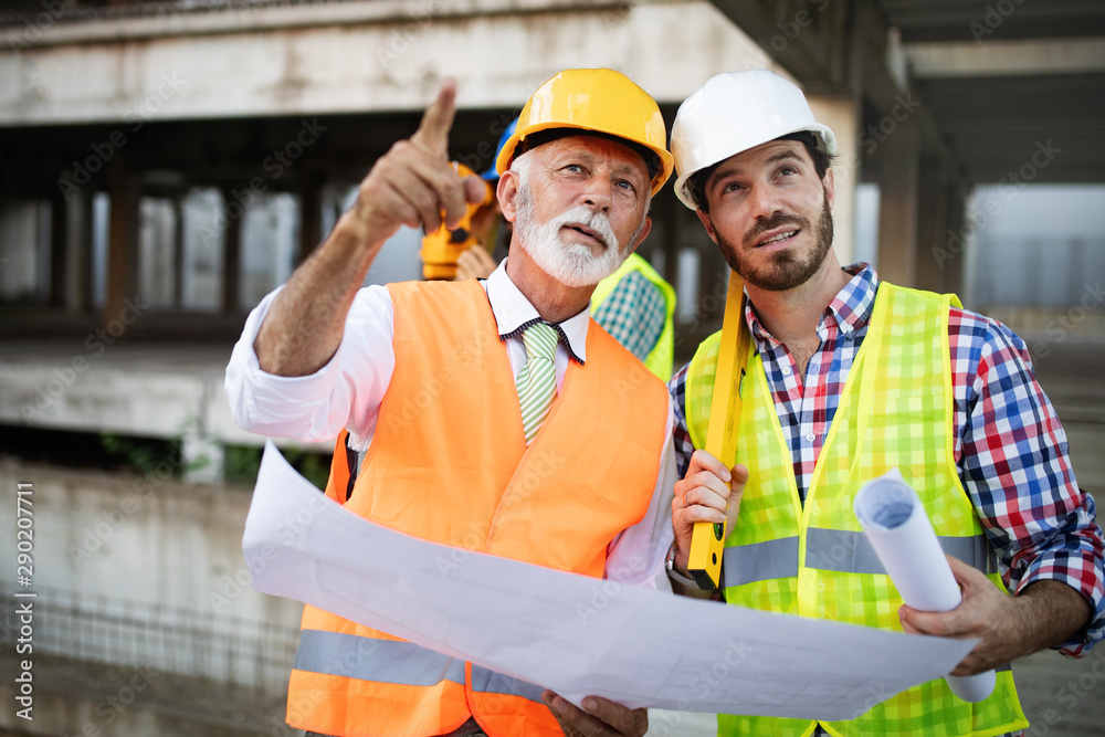 Wall mural confident team of architects and engineers working together on construction site