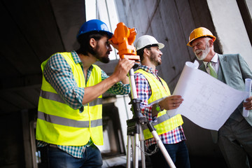 Engineer and construction site manager dealing with blueprints and plans