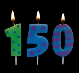 Burning birthday candles on black background, number 150