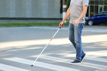 Blind mature man crossing road outdoors