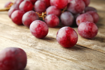 Ripe sweet grapes on wooden background, closeup