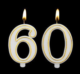 Burning birthday candle isolated on black background, number 60