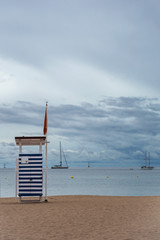 Fototapeta premium gazebo rescue service on a deserted evening sandy beach on a background of yachts and a cloudy sky