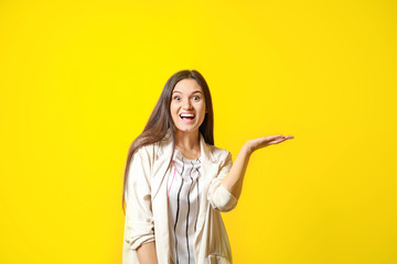 Portrait of excited young woman on color background