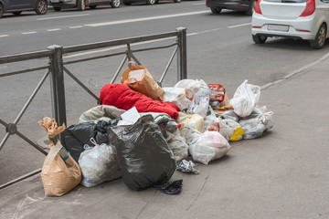 a pile of household garbage on the sidewalk by the road, waiting for evening cleaning