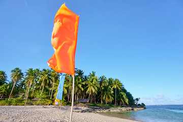 Beautiful landscape. White sand beach with colorful flags on it. Siargao Island, Philippines.