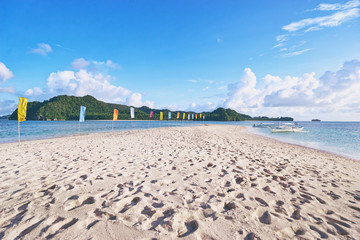 Beautiful landscape. White sand beach with colorful flags on it. Siargao Island, Philippines.