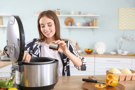 Woman using modern multi cooker in kitchen
