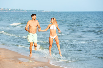 Happy couple running on sea beach