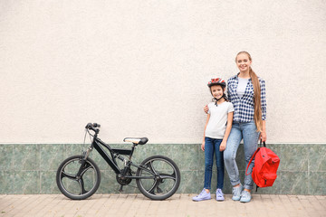 Plakat Woman and her little daughter with bicycle outdoors