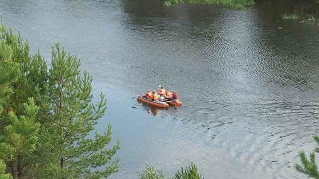 Autumn river rafting. Inflatable catamaran with people floating on the river