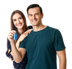 Happy couple with key from their new car on white background