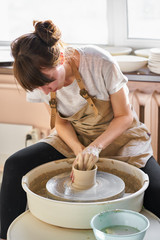 Fototapeta na wymiar Woman making ceramic pottery on wheel, hands close-up. Concept for working woman in freelance, business, hobby