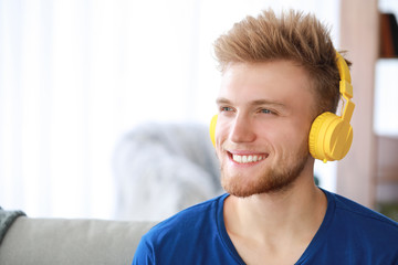 Naklejka premium Handsome young man listening to music at home