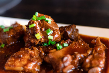 Close up and selective focus of Stewed pork ribs and herbal soup in white plate. chinese style food.