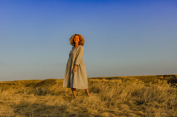 amazing girl in a hat at sunset in the steppe on the sea
