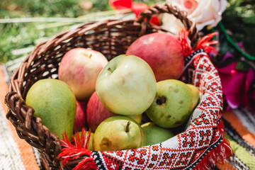 Naklejka na ściany i meble Fruit basket apples and pears over autumn bokeh background. Thanksgiving dinner. Autumn nature concept.